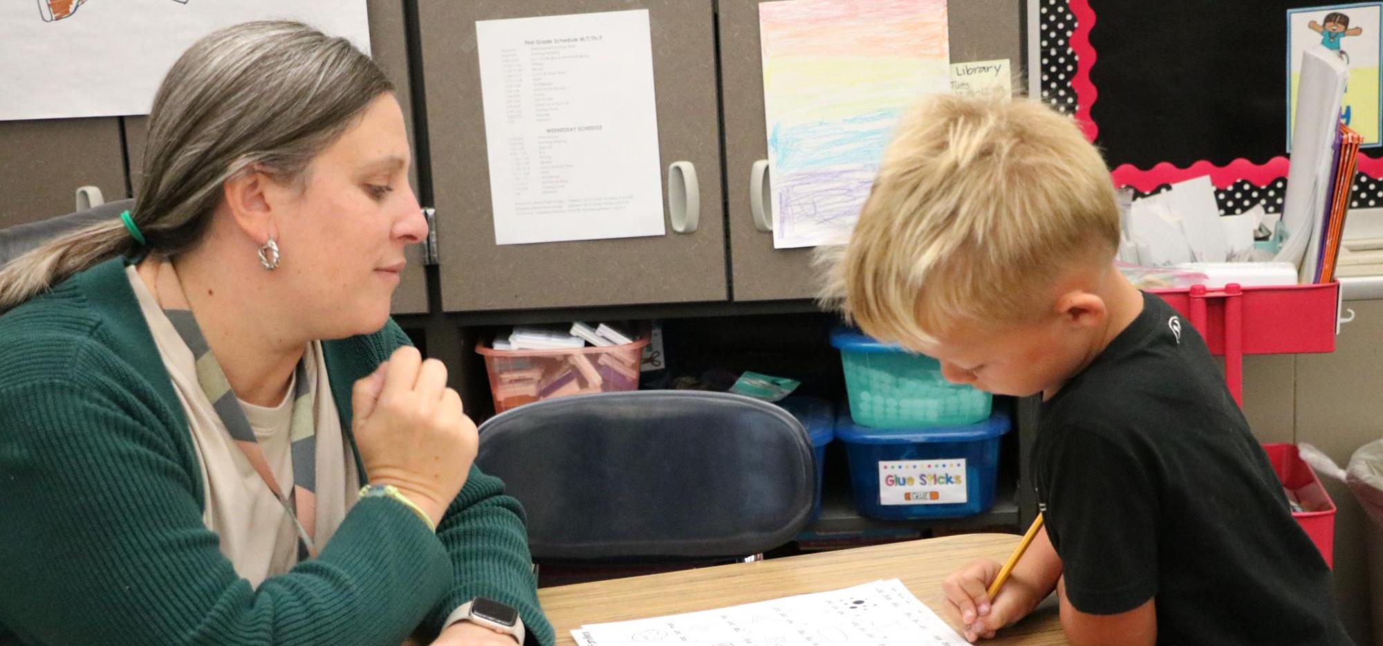 1st grade student and teacher working